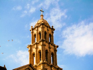 The bell tower of the cathedral in Ciudad Juárez against a blue sky