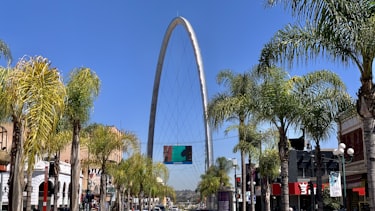 The tall steel arch over Avenida Revolución in Tijuana, with palm trees